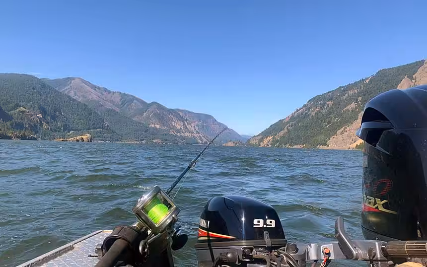 Columbia River fishing guide's boat with motor and fishing rod on the water.