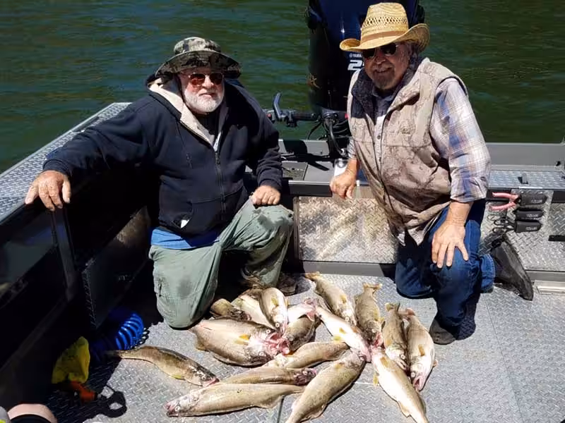 Two men on a a boat showing where to catch walleye on the columbia river