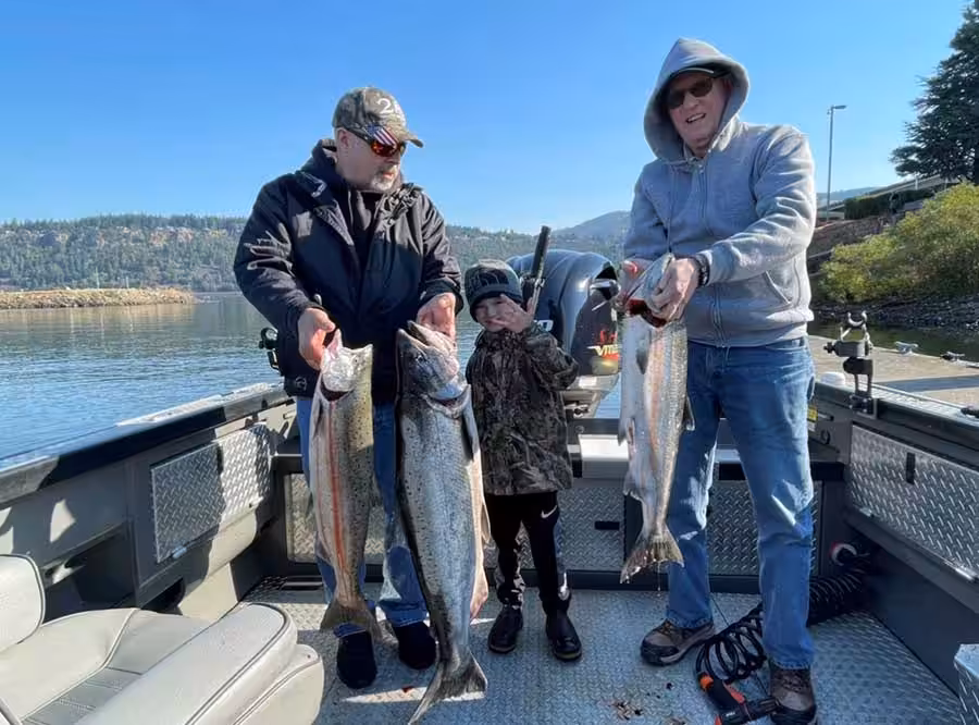 Three person holding salmon while fishing in Portland Oregon.