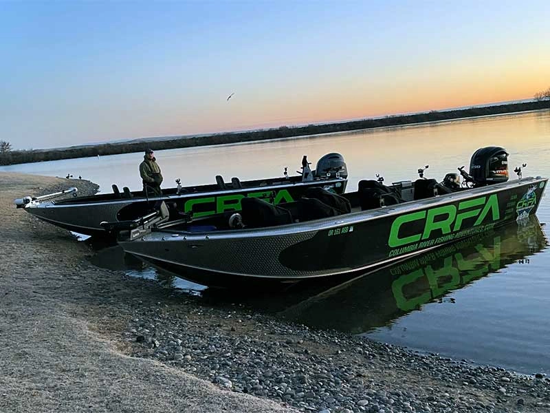Two professional jet boats on the shore at sunrise, ready for clients hiring Columbia River fishing guide services for salmon and sturgeon trips.