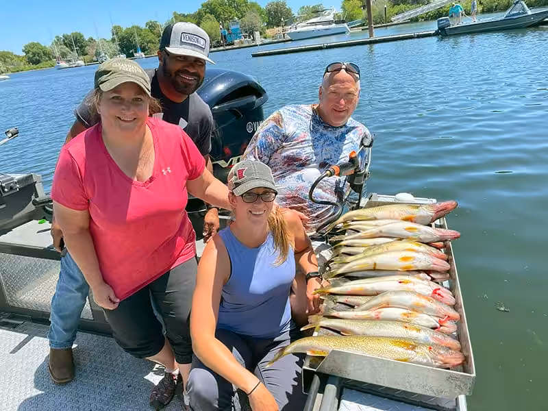 Four people on a boat with their catch during Walleye Fishing on the Columbia River.
