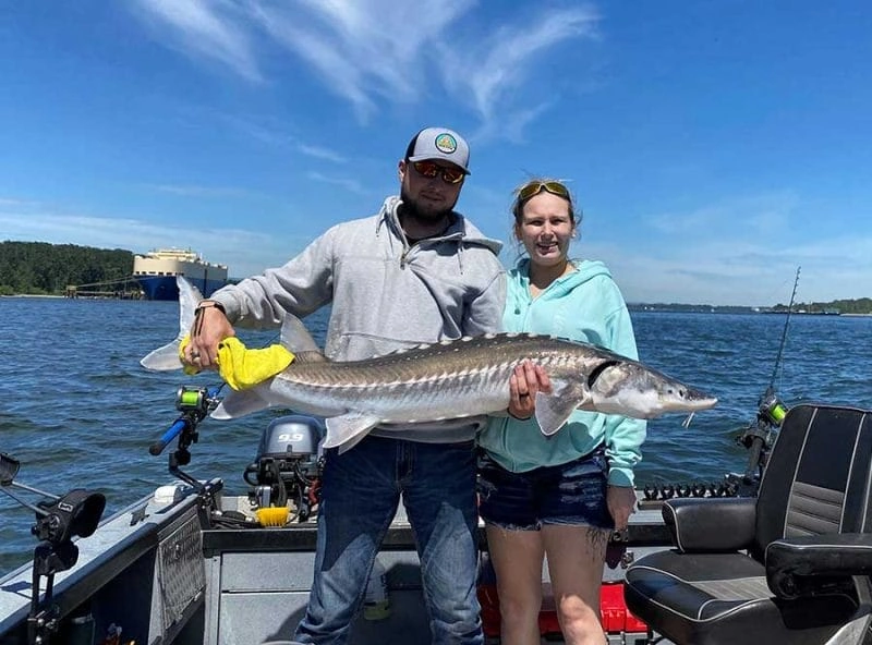 Two people holding a large fish during their fishing in Portland Oregon