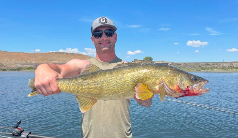 A person proudly displaying a large fish illustrating the excitement of fishing in Rufus Oregon.
