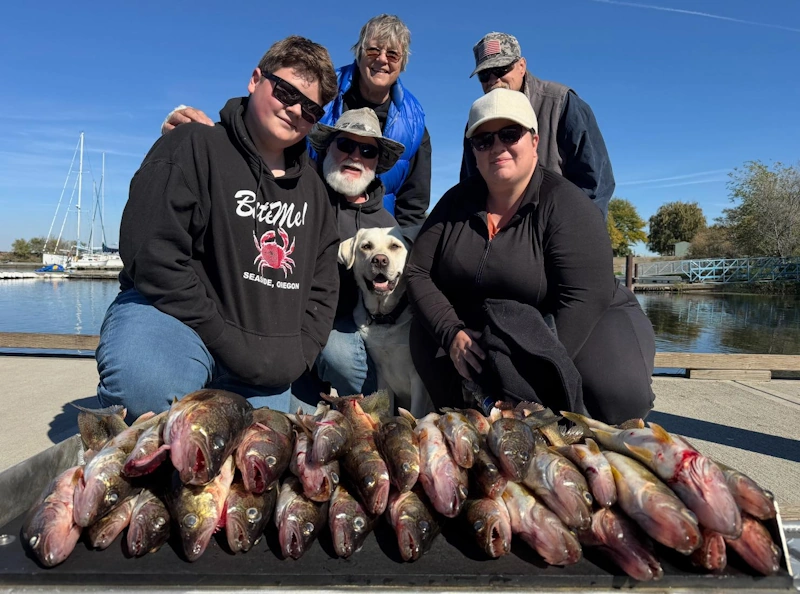 walleye fishing with columbia river fishing adventures A group enjoying walleye fishing in Oregon — showing off their fresh catch with their dog on the dock.